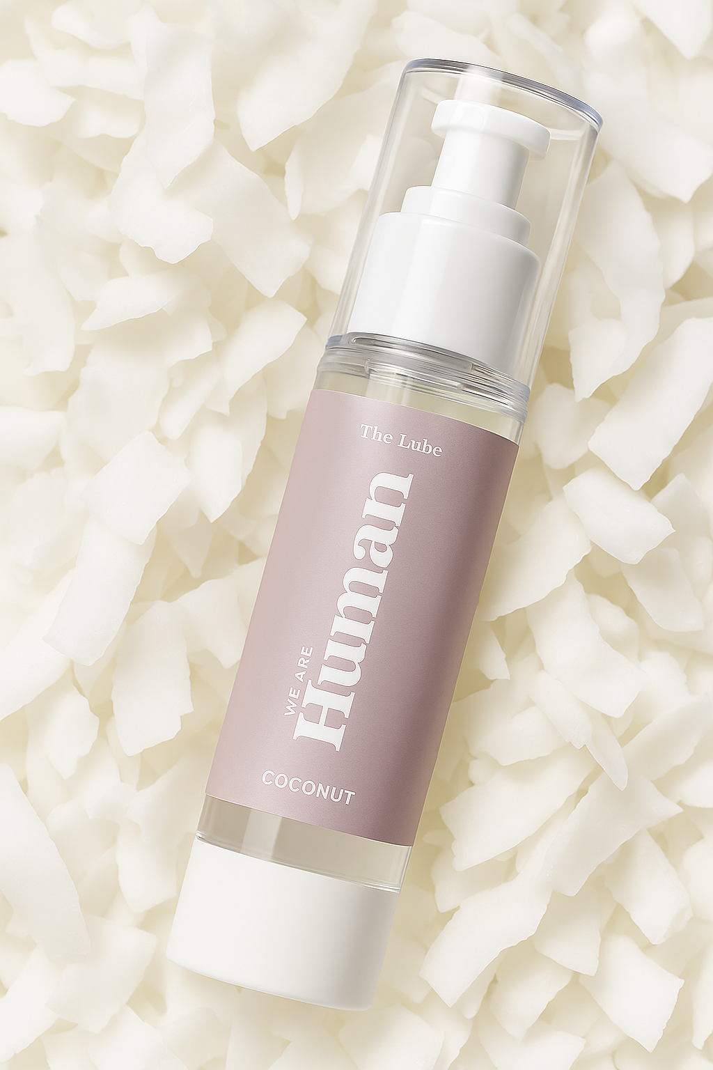 The Lube – Coconut, water-based personal lubricant by We Are Human lying on a bed of coconut flakes